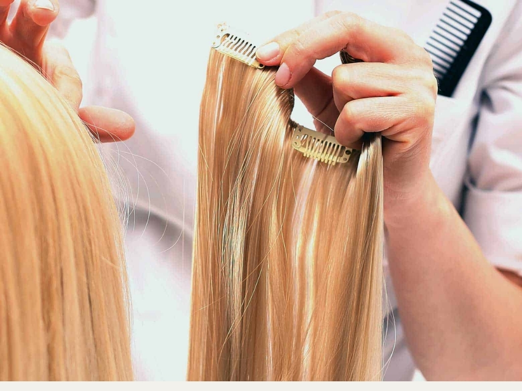 How Do Clip In Hair Extensions Work? A Beginner’s Guide 3 Hands holding blonde clip in hair extensions, showing how clip in hair extensions work