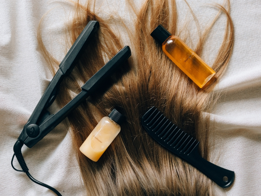 Tools and products: hair straightener, comb, hair serum, and hair extensions