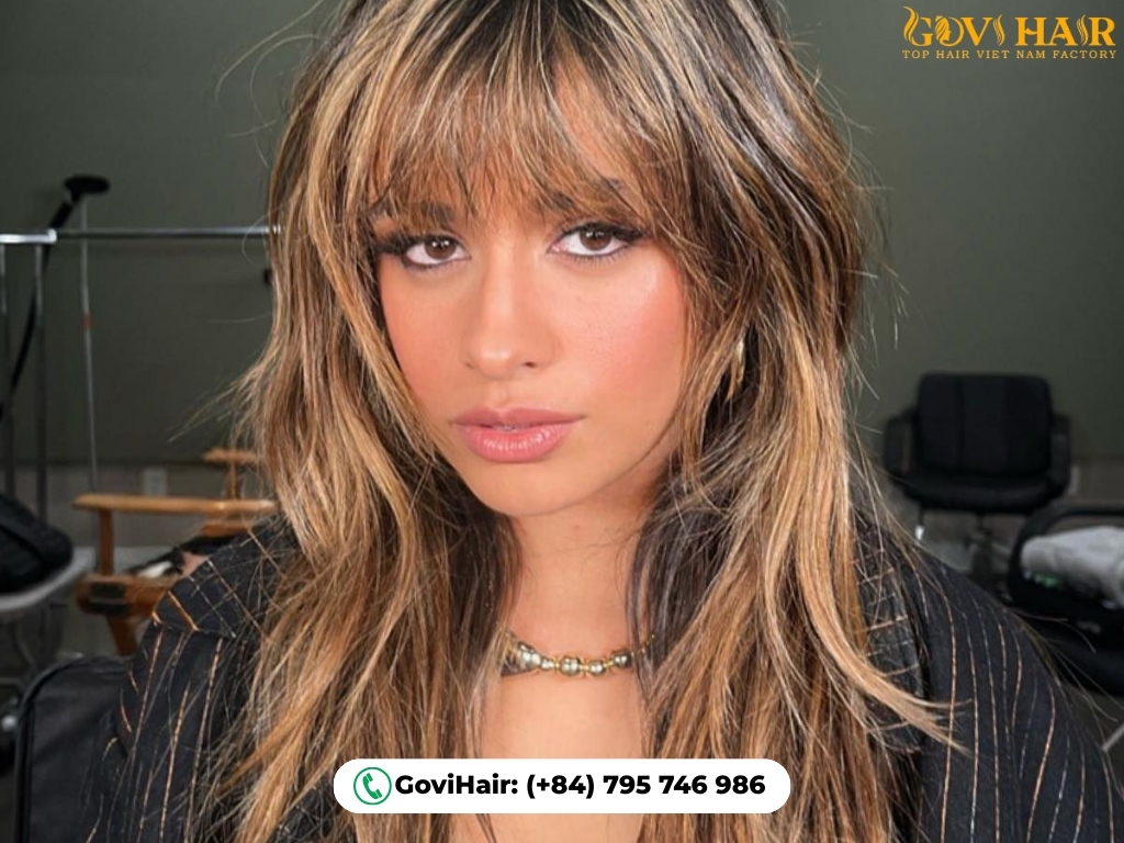 Layered wolf cut with highlights and piecey, textured bangs