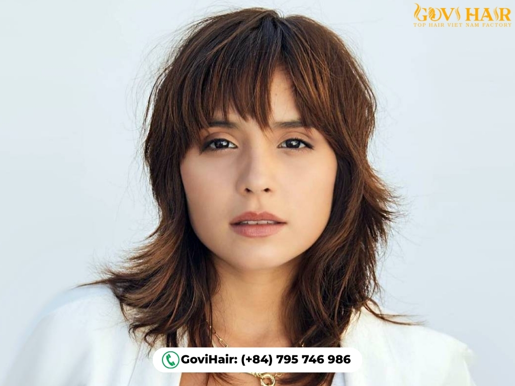 Messy layered wolf cut with thick, blunt eye-framing bangs