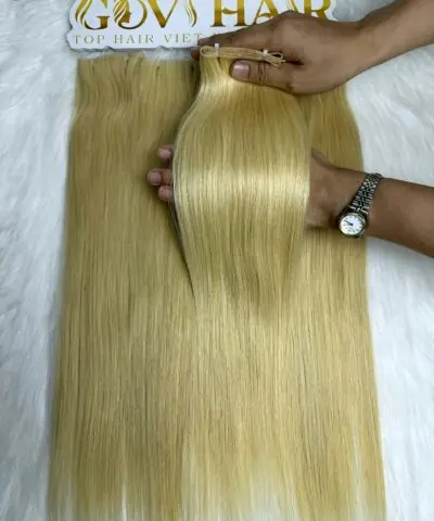 Genius hair wefts #613 blonde held by hand
