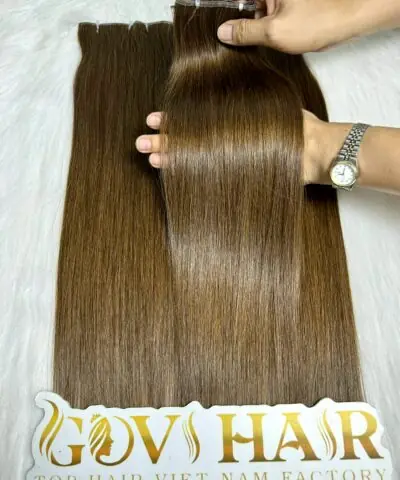 Genius weft extensions dark brown held by hand