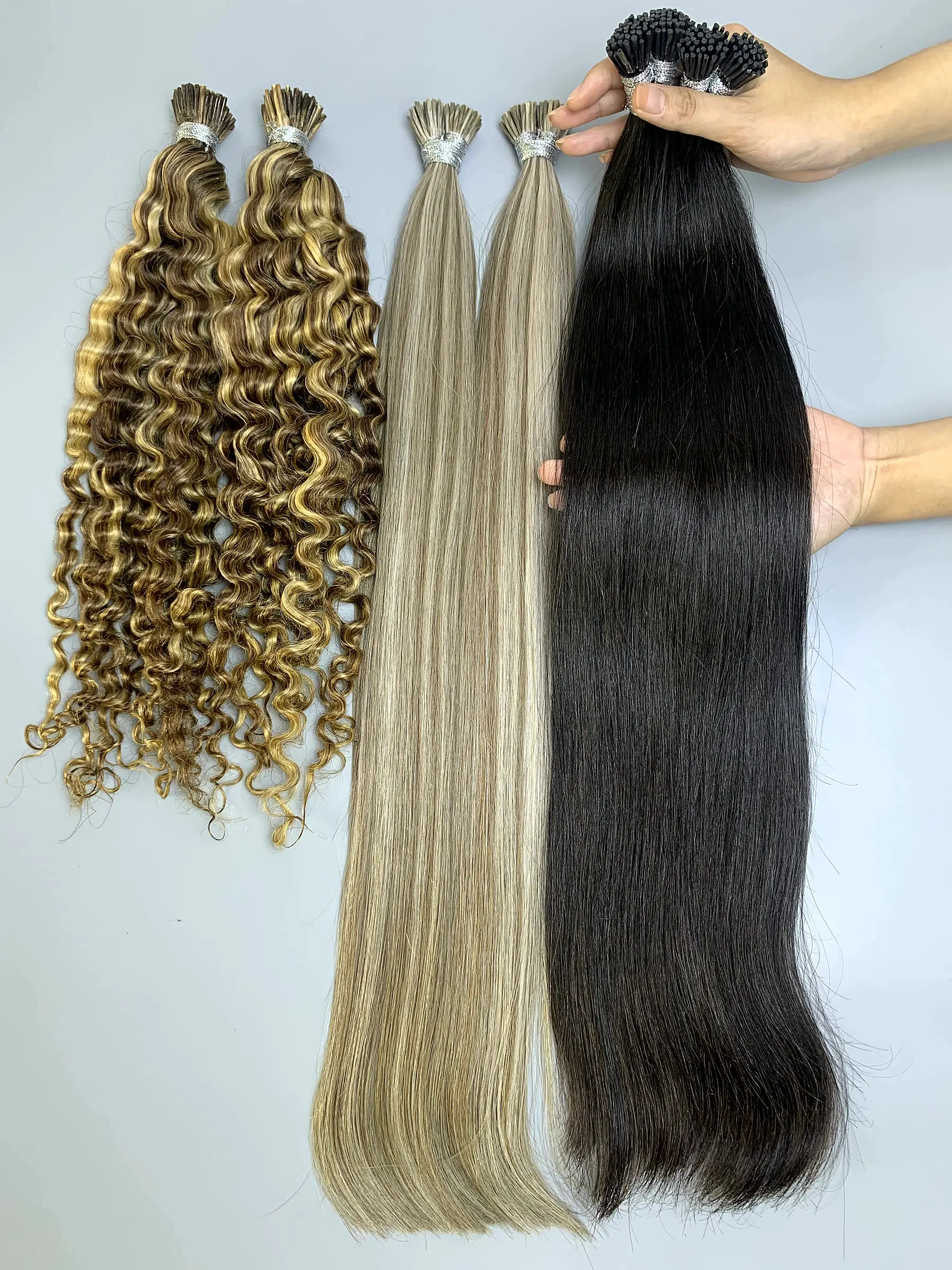 24 Inch I Tip Raw Hair Extensions Natural Straight Natural Black Wholesale 1 I tip hair extensions held by hand showing shine