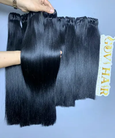 Super Premium raw hair bundles held by hand showing shine