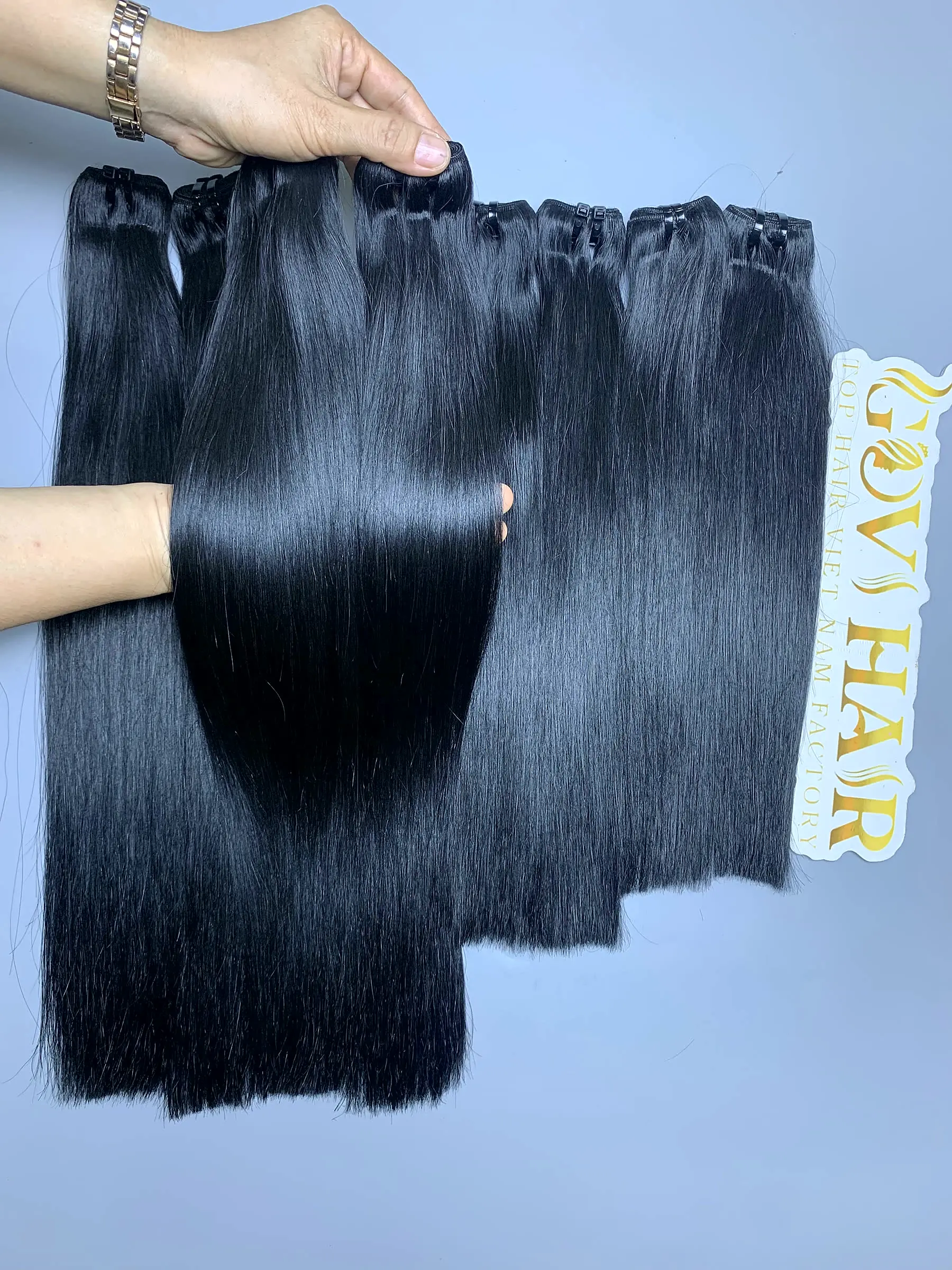 14 16 20 Inch Raw Human Hair Bundles Bone Straight Super Premium Wholesale 1 Super Premium raw hair bundles held by hand showing shine