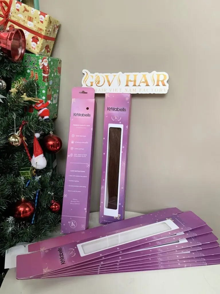 Custom pink private label window boxes with bespoke hair extensions, in front of the Govihair sign