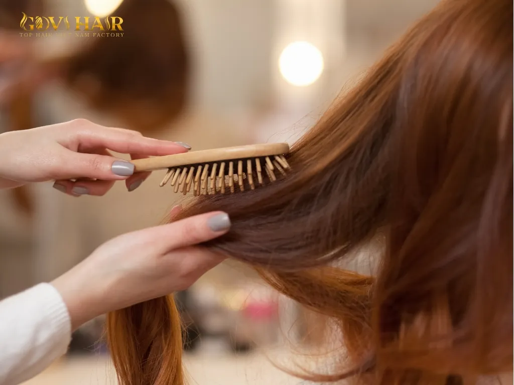 Brushing and detangling 40 inch hair as part of proper maintenance routine