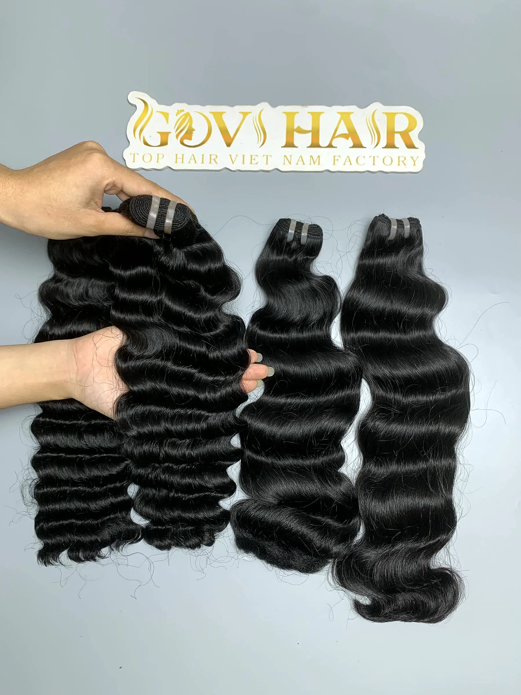 raw hair bundles with deep curly and natural wave held by hand showing shine