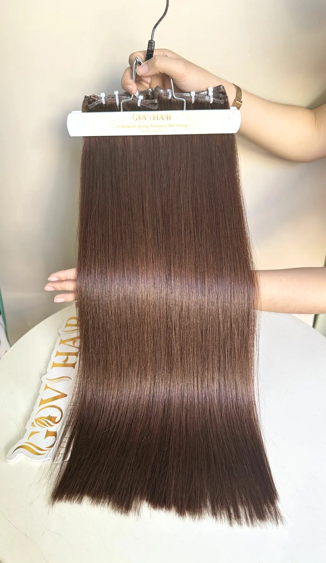 Genius weft hair #4 brown held by hand